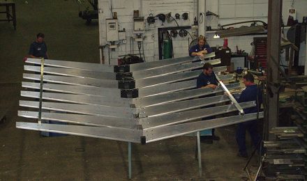 Four men attaching parts to steel fabricated Starbucks canopy