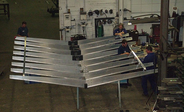 Four men attaching parts to steel fabricated Starbucks canopy