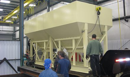 Beige painted rap bin being loaded into truck