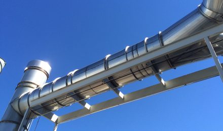 Stainless steel flanged duct against blue sky