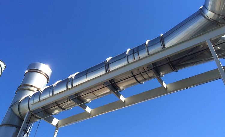 Stainless steel flanged duct against blue sky